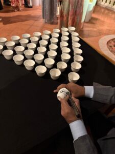 Pakistani calligrapher in Dubai, Alfirdous, at a live Arabic calligraphy event at Kempinski Hotel, Jumeirah, Dubai, creating elegant artworks for attendees.